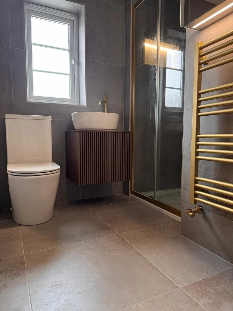 Dark grey tiled bathroom with slatted walnut vanity unit and brushed gold fittings — bathroom installation Nottingham