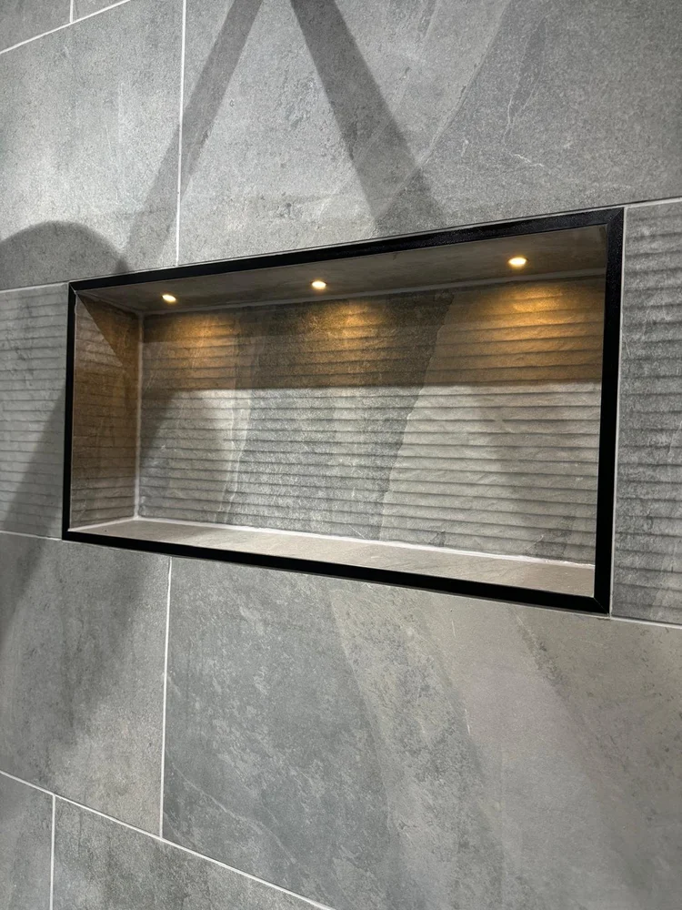 Illuminated shower niche with three integrated spotlights and textured tile lining — bathroom installation Nottingham