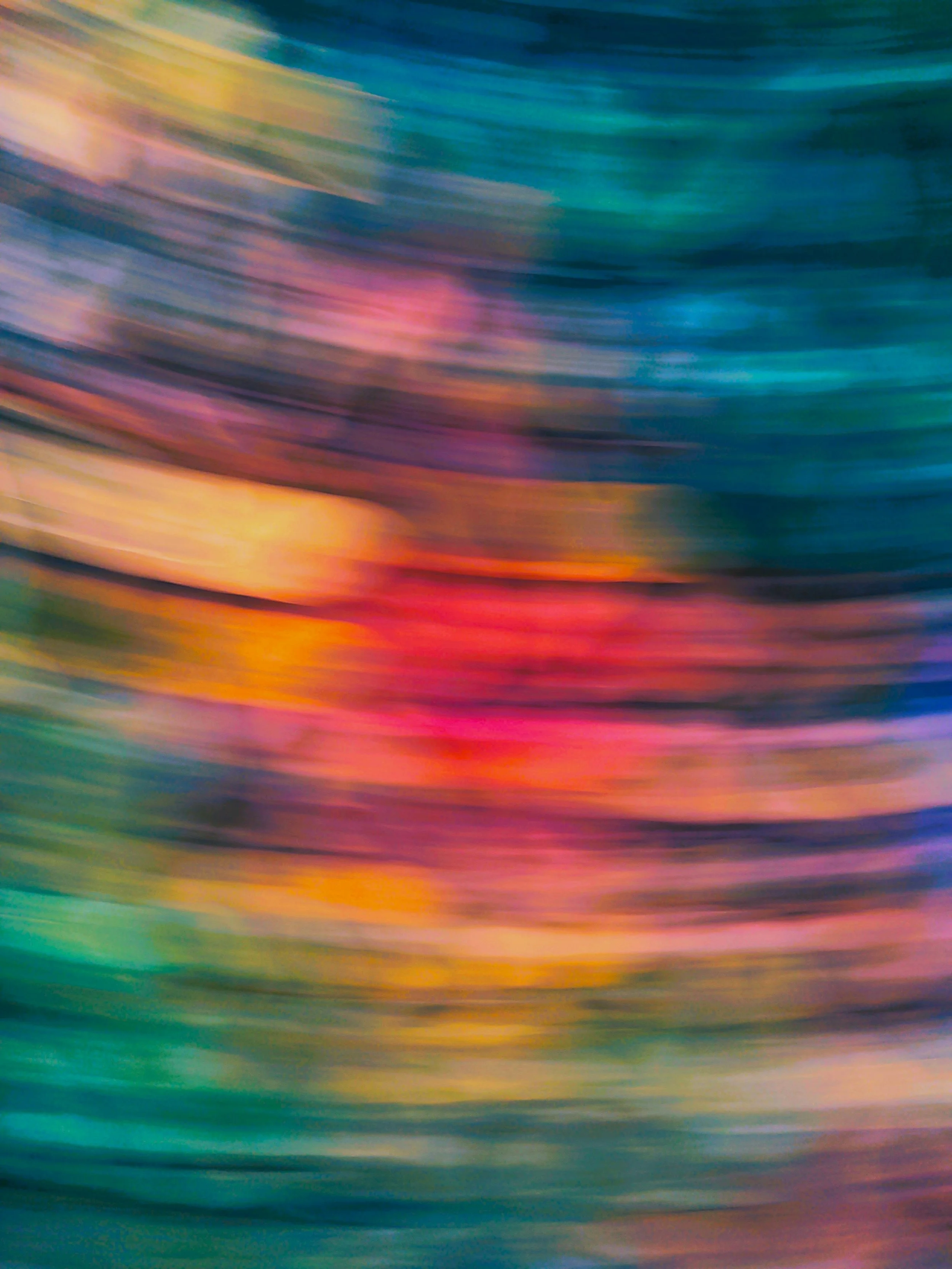 Abstract colorful streaks of paint blending into each other, with shades of yellow, pink, blue, green, and orange.