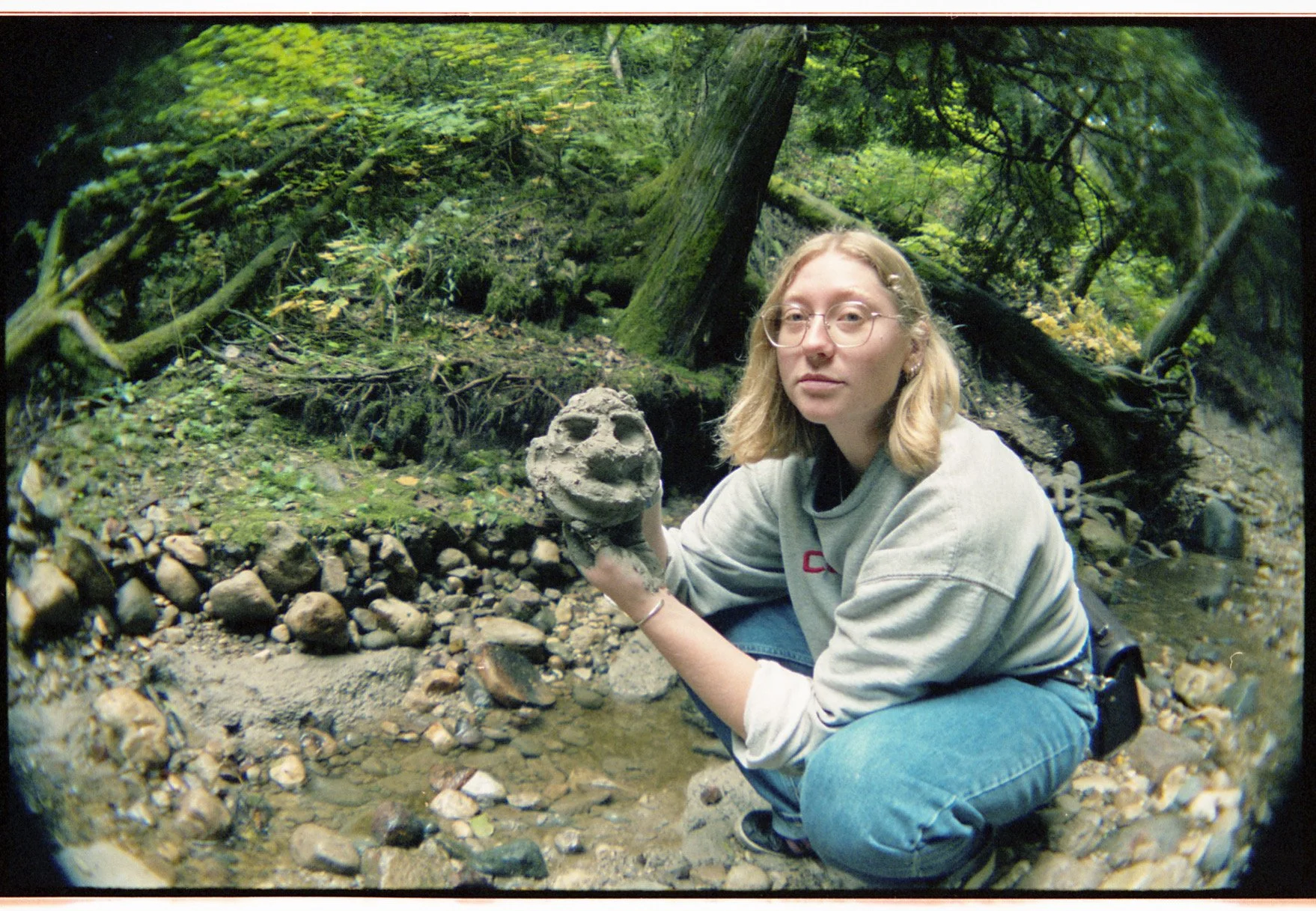 Female artist creating sculpture out of creek clay