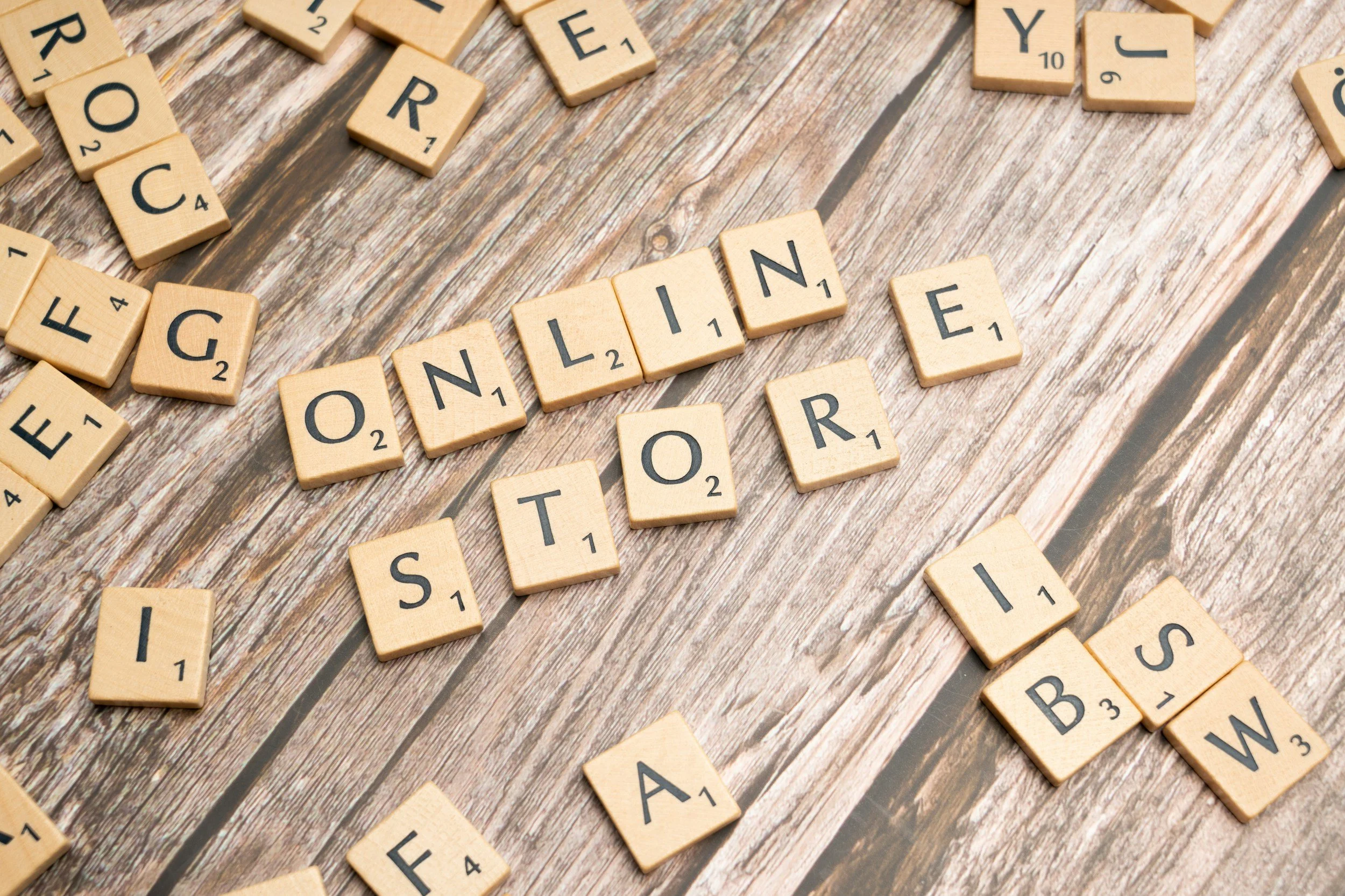 Scrabble tiles on a wooden surface spelling out 'ONLINE ORDER'
