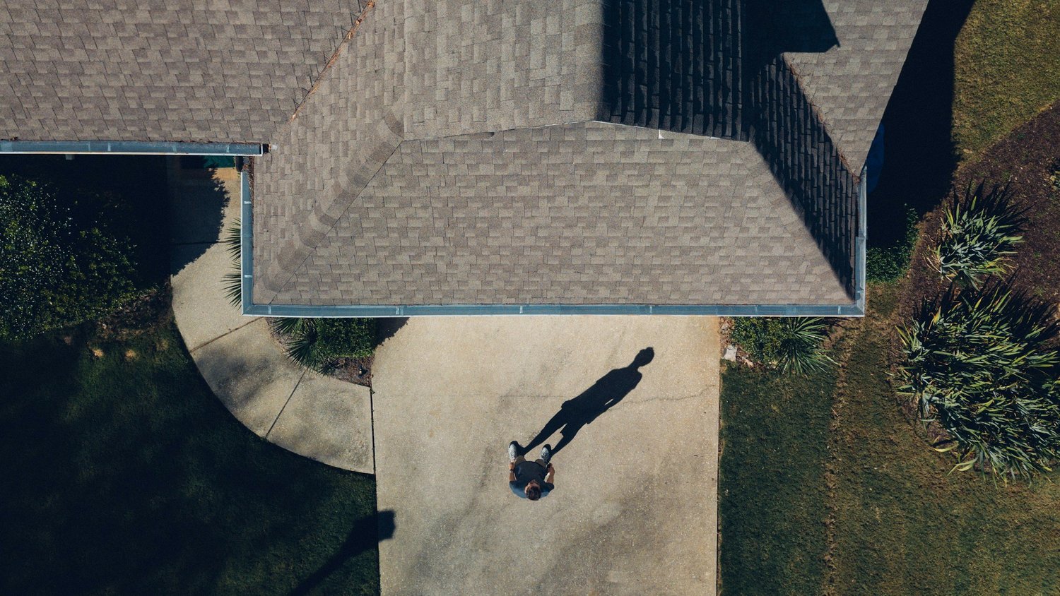 Overhead view of a house roof, gutter line and driveway