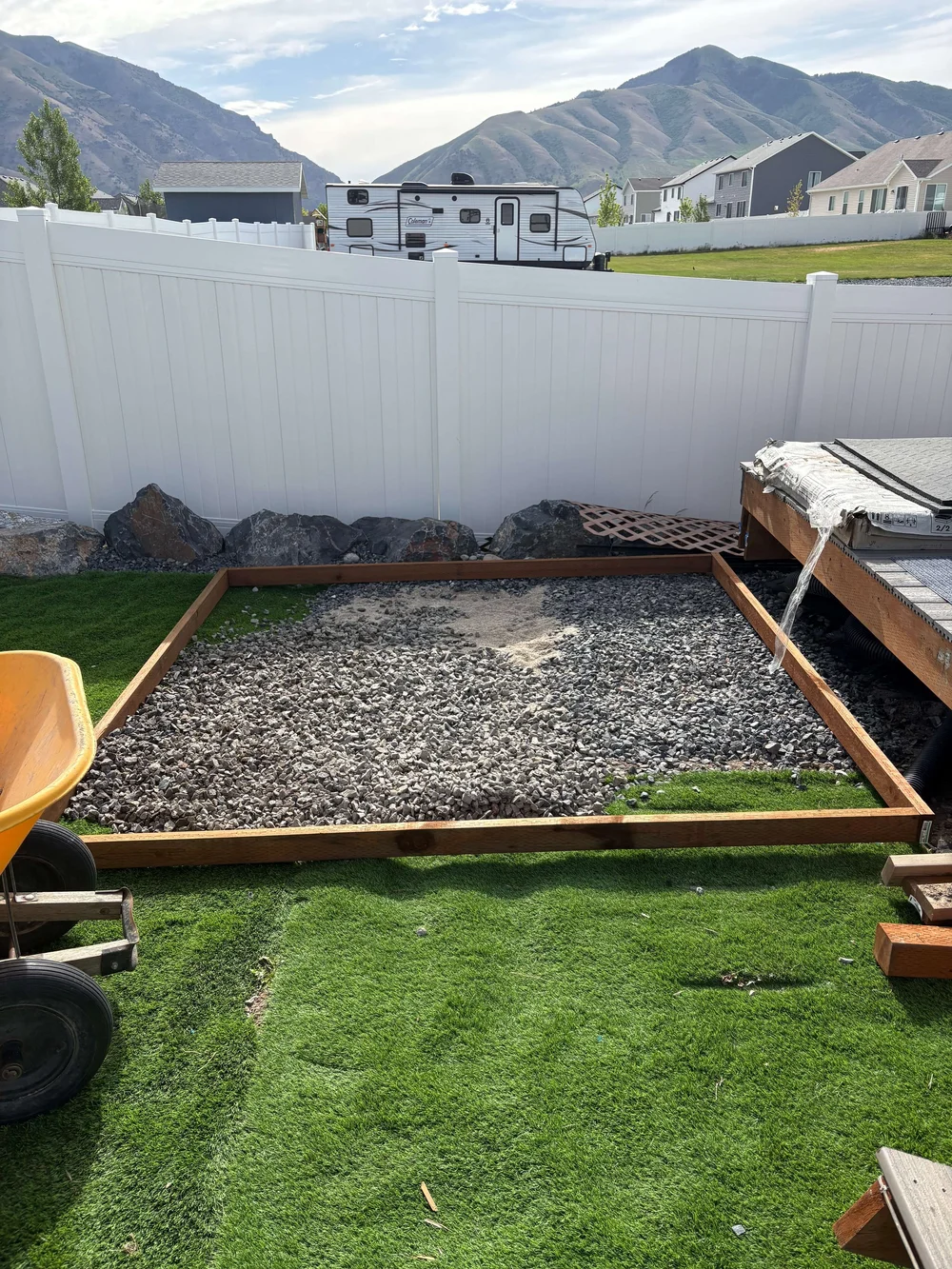 A prepared gravel pad in a back yard before the shed was built