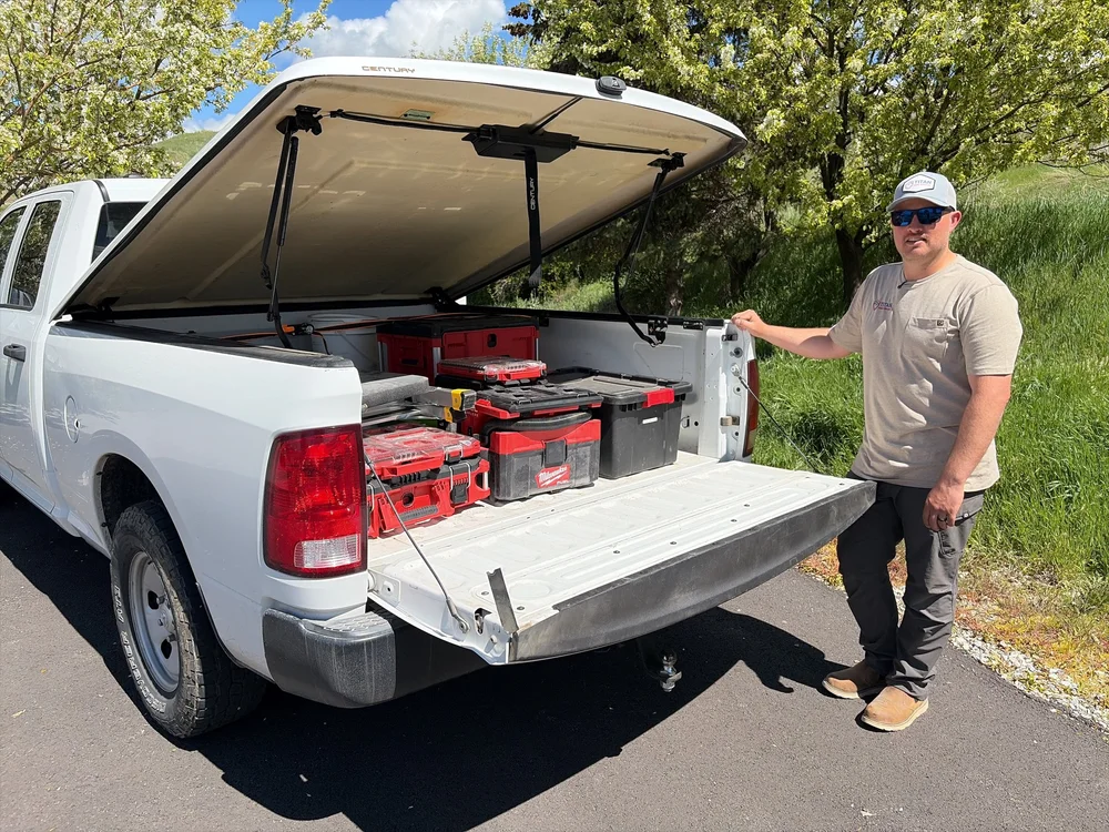 Brendan at his truck with the bed open and tool cases loaded