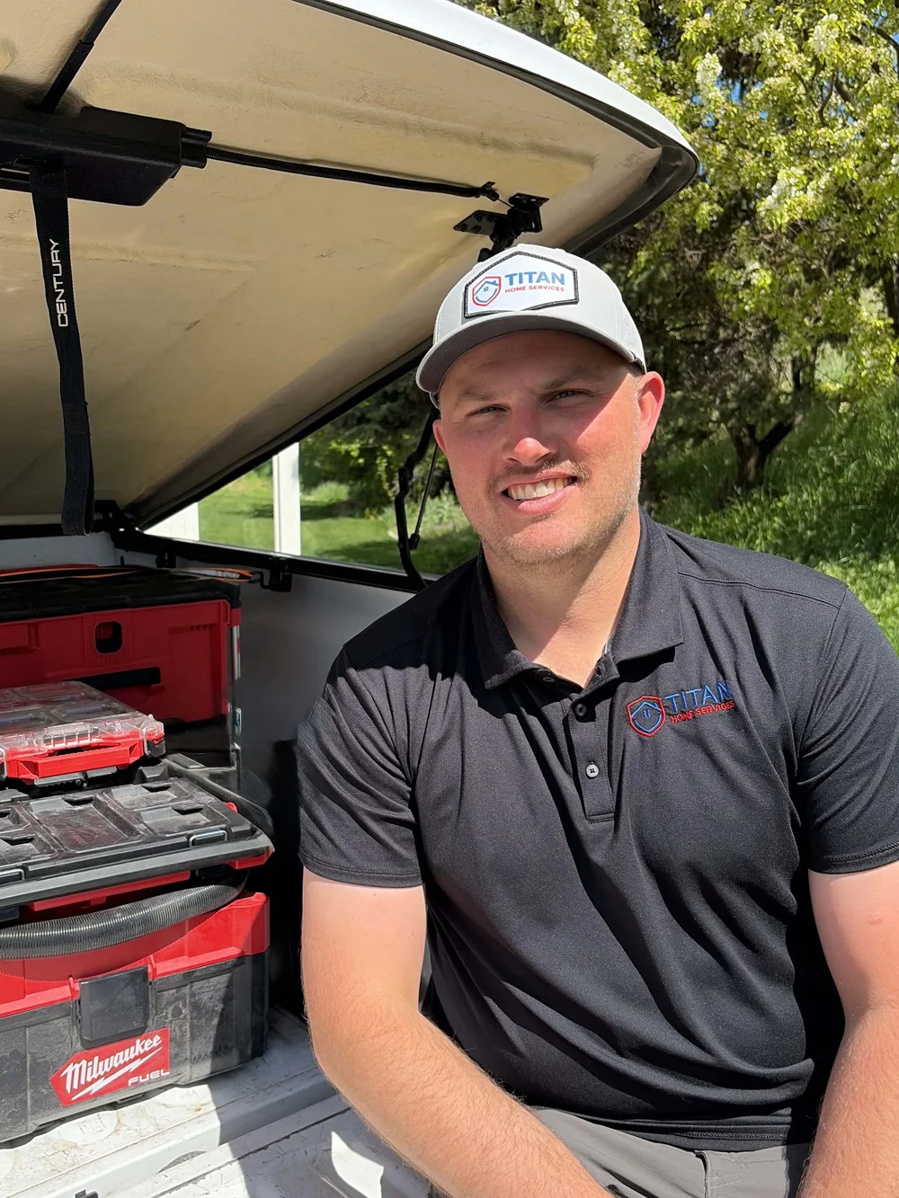 Brendan Michael, owner of Titan Home Services, at the open tailgate of his work truck