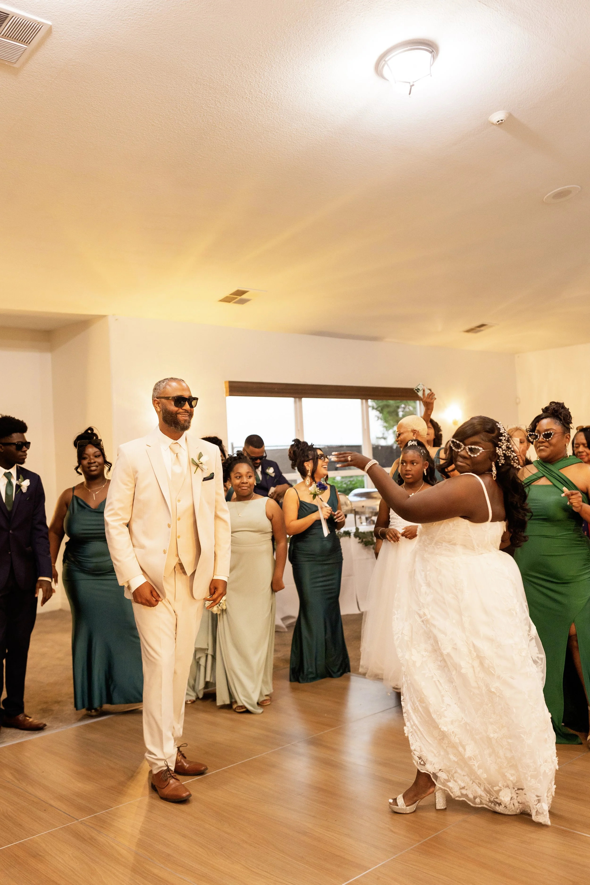 A wedding reception with the bride and groom dancing in the center surrounded by guests.