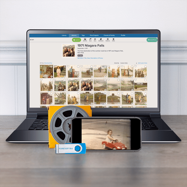 Laptop and smart phone showing digital photos and a playing video.