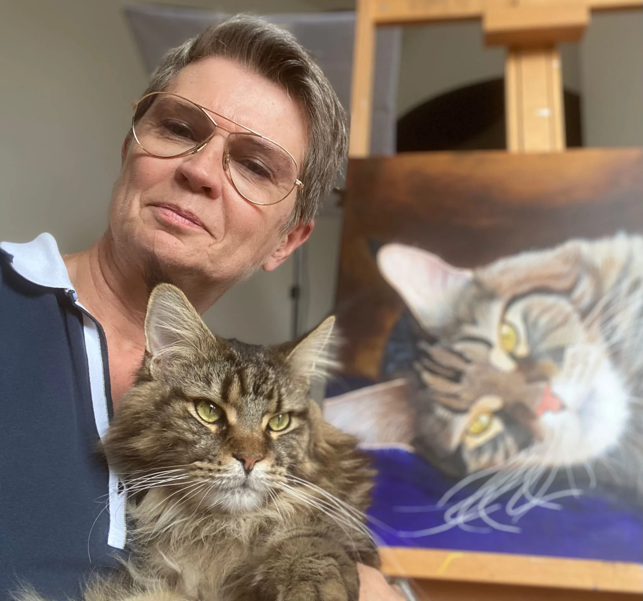 Lydia Mériaux, artiste peintre, dans son atelier en Picardie avec son chat, devant un portrait animalier en cours de réalisation