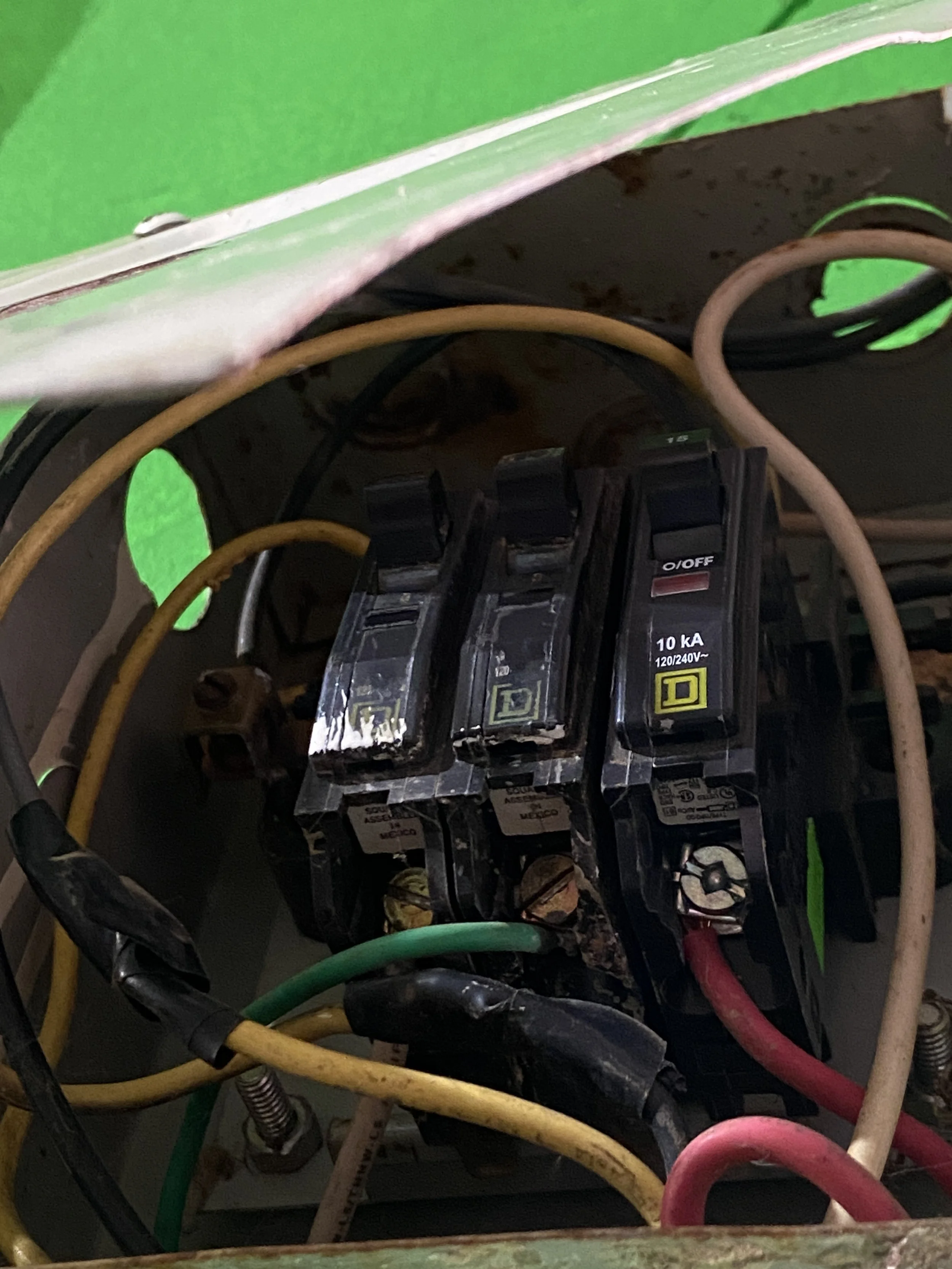 Interior de un cuadro eléctrico con varios cables de diferentes colores y un interruptor visible.