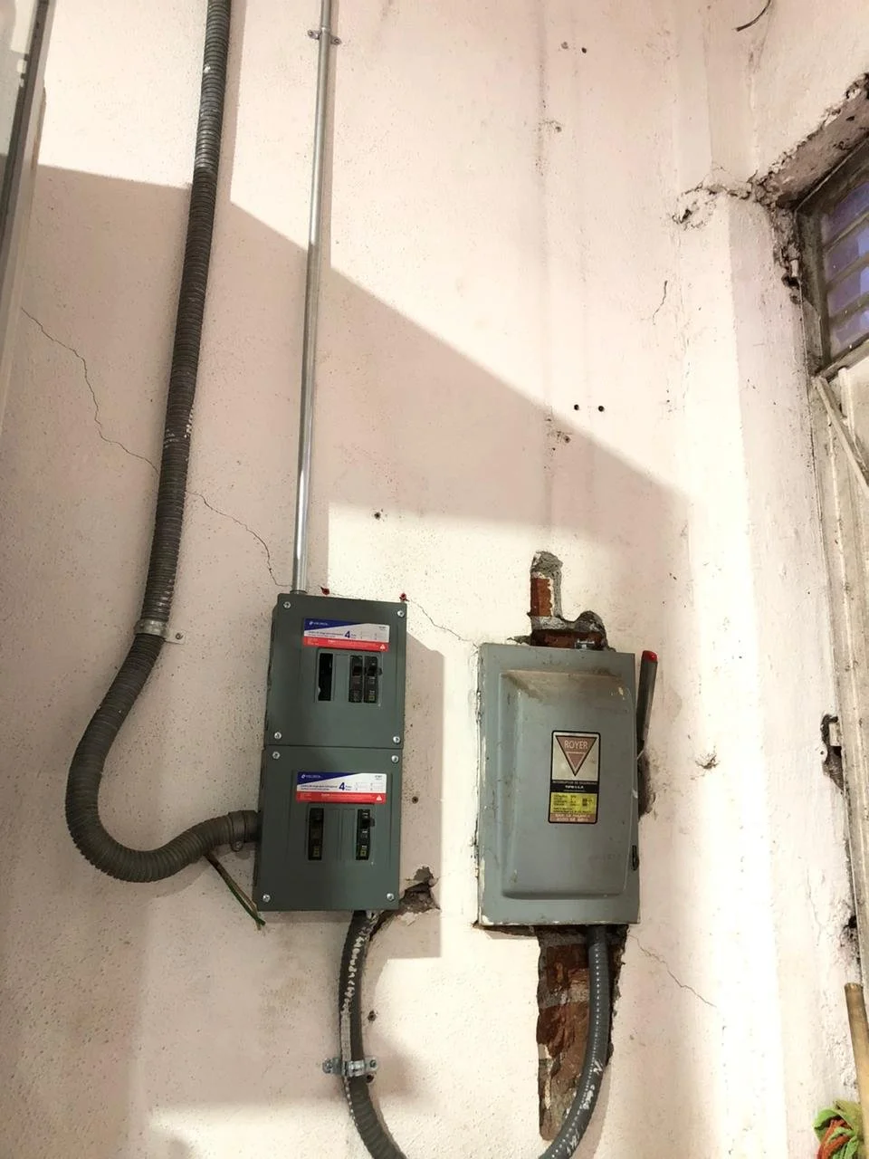 Tableros eléctricos y cables en una pared de un edificio en construcción o reparación.