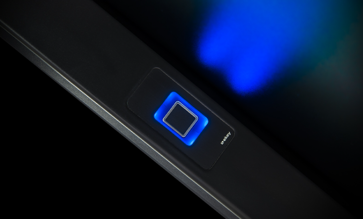 Close-up of a laptop power button with blue LED light.