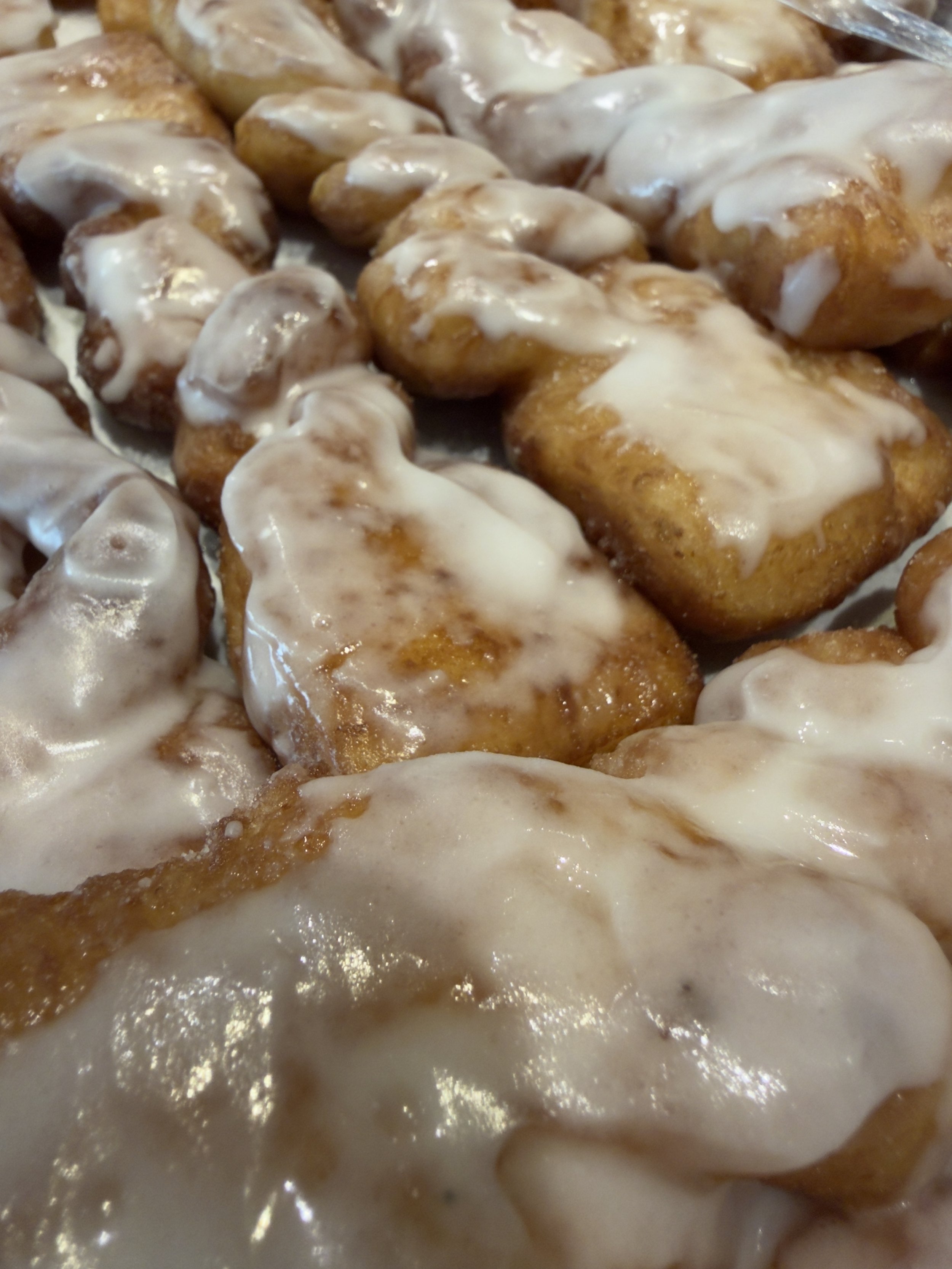 Close-up of cinnamon rolls topped with white icing.
