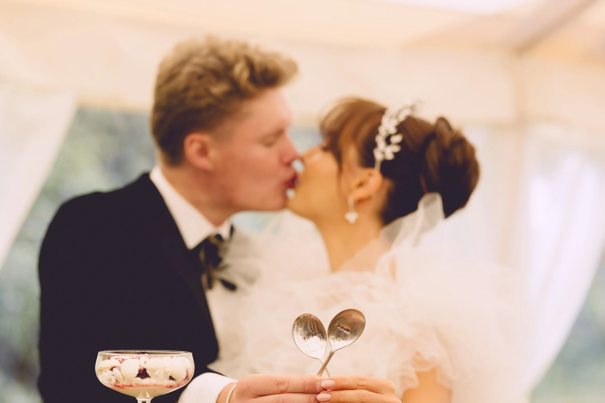Bride and groom kissing with love spoons 