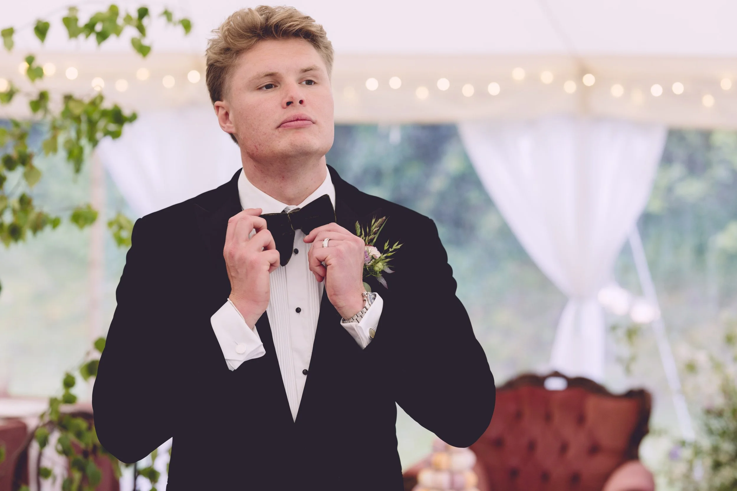 Groom adjusting his bow tie