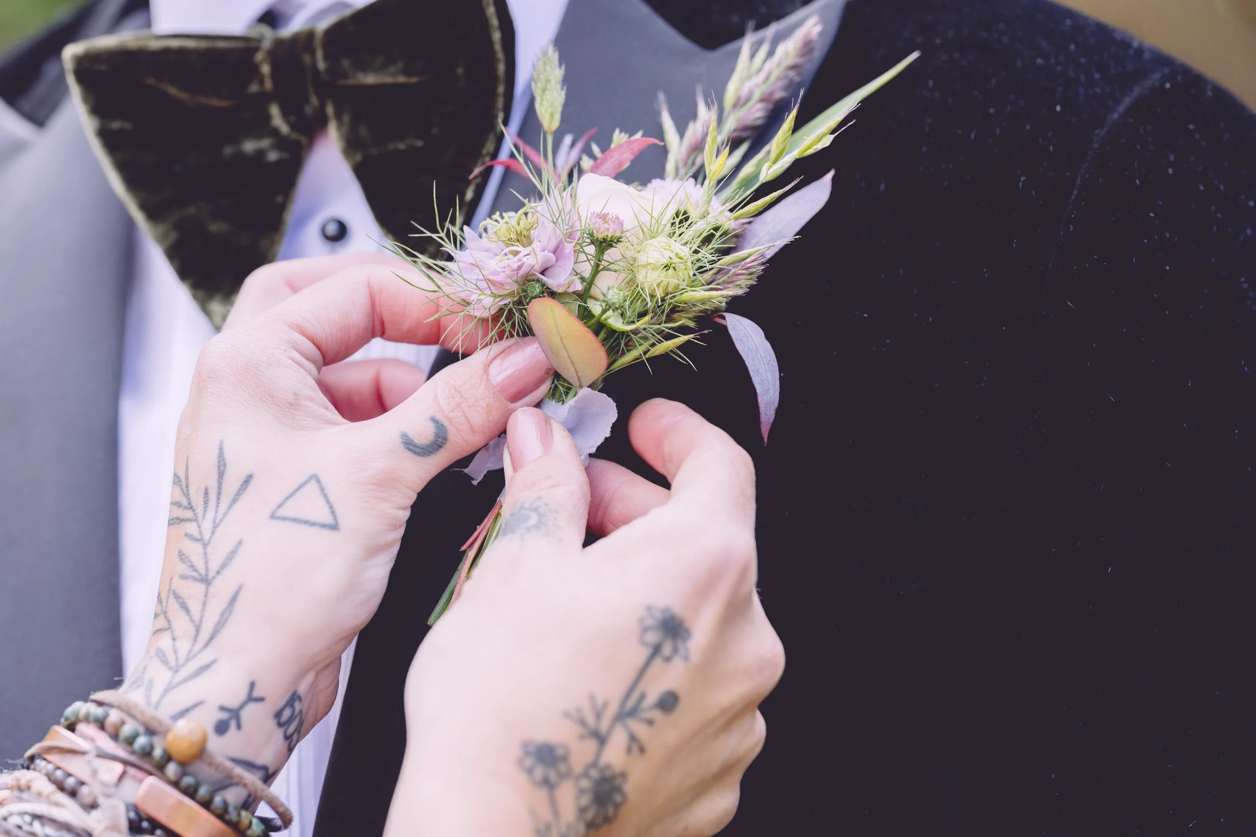 Groom's  boutonnière or buttonhole being attached to jacket