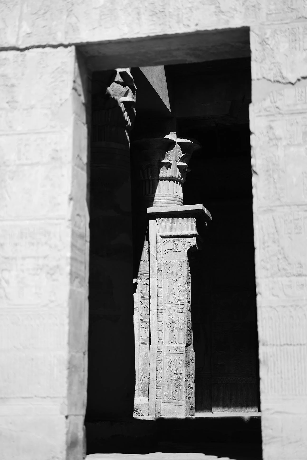 Colonnes gardant des hiéroglyphes égyptiens, vu entre deux murs en pierre.
