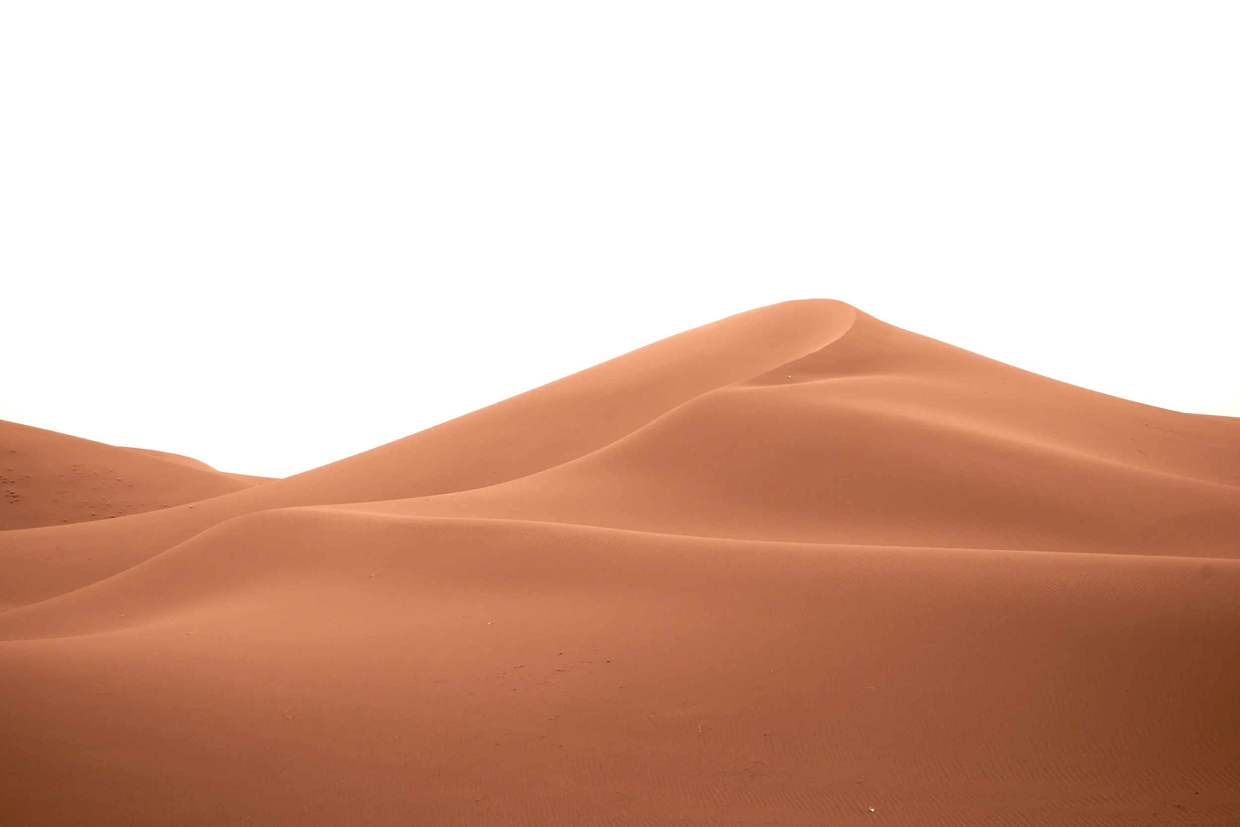 Dunes de sable dans un désert avec un ciel blanc