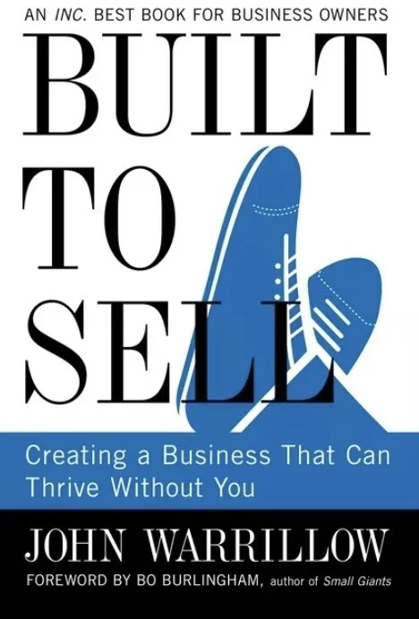Book cover titled "Built to Sell" by John Warrillow, featuring an illustration of a surfboard and a shoe, with subtitle "Creating a Business That Can Thrive Without You."