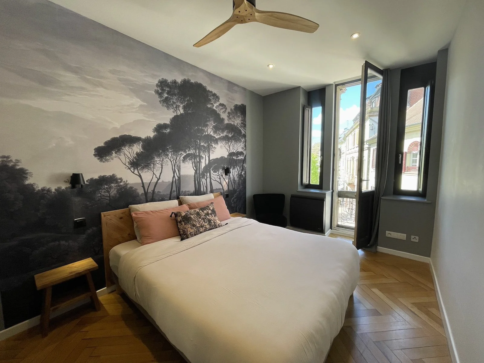 Larges ouvertures avec balconnet dans la chambre avec ventilateur de plafond 