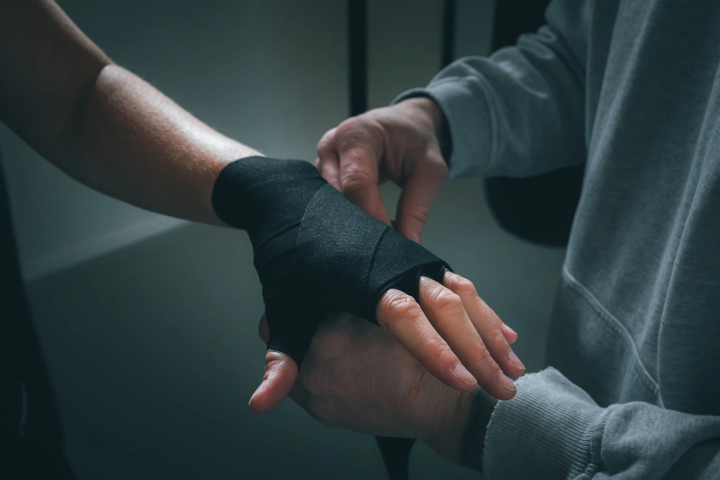 Persoon met een kniebrace helpt iemand met een gewonde arm.
