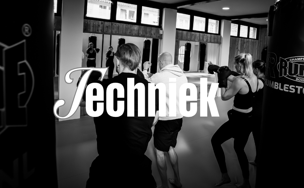 Mensen die in een fitnessruimte bokszakken trainen.