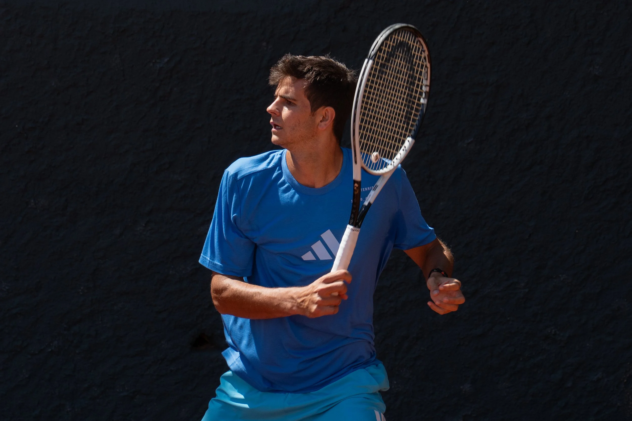 Rafa Jodar in a blue shirt and shorts holding a tennis racket during a match.