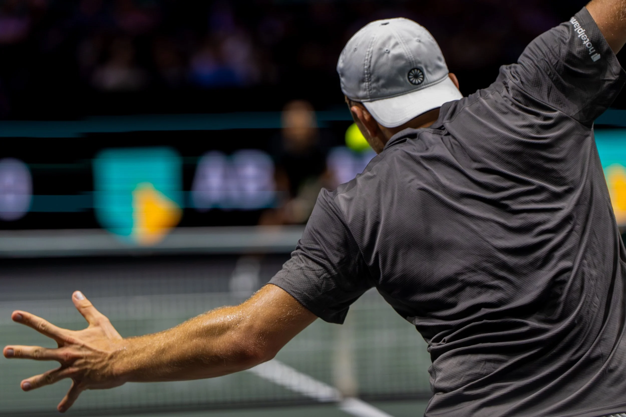 Tallon Griekspoor hits a tennis ball with a racket on an indoor court.