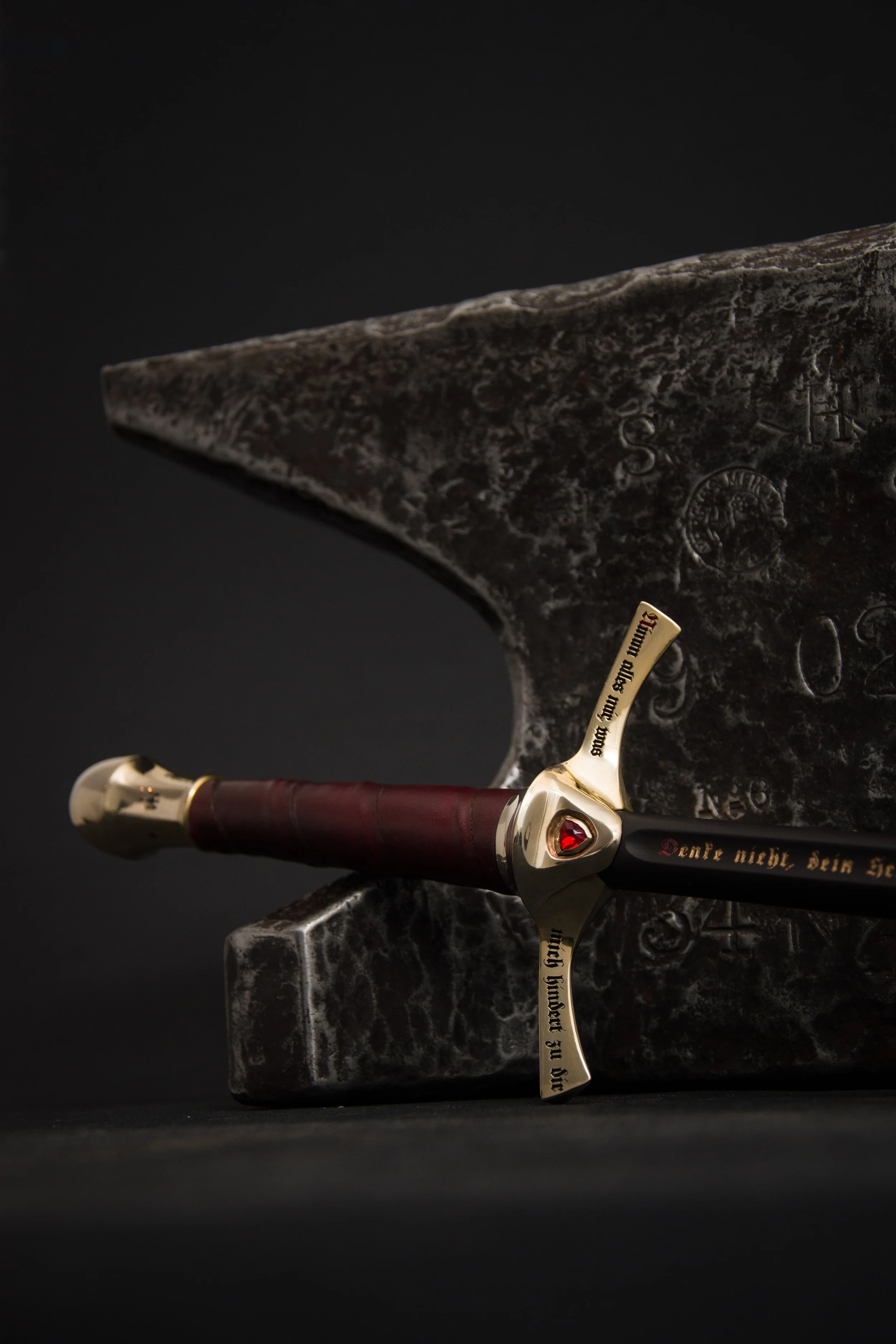 hookah handle in style of a medieval sword with a inlayed red gemstone. Writing engraved with color into sword parts with medieval poems