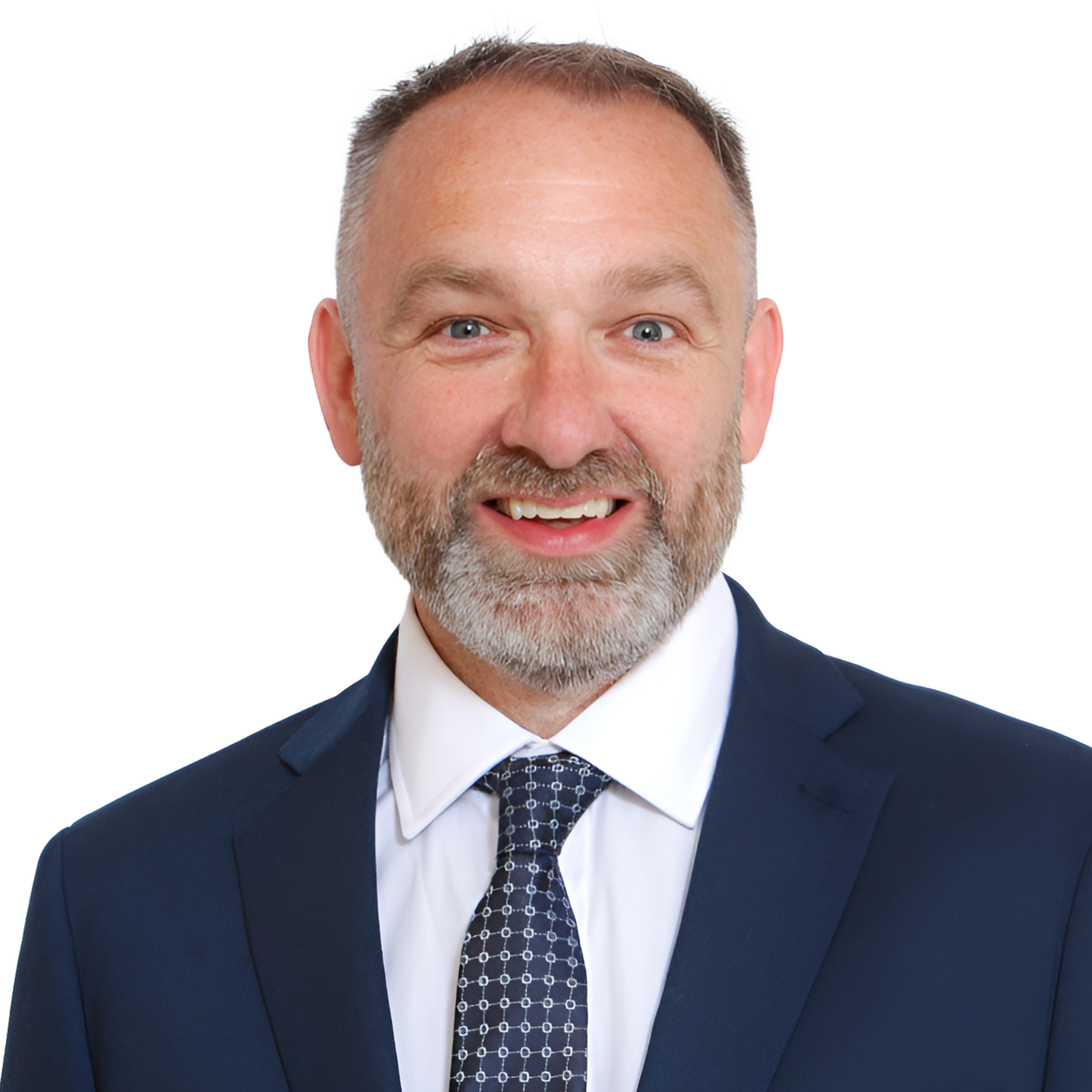 A portrait of a middle-aged man with short gray hair, blue eyes, and a gray beard, wearing a navy blue suit, white shirt, and patterned tie, smiling confidently.