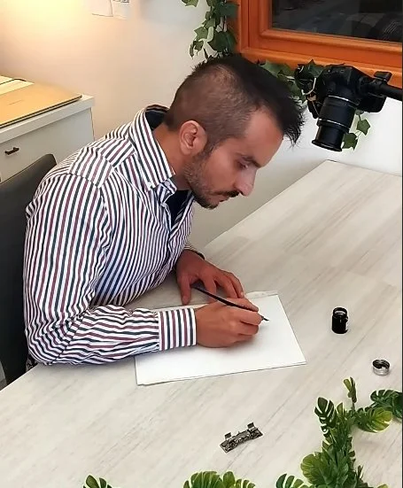 Francesco Di Giuseppe writing with a dip pen