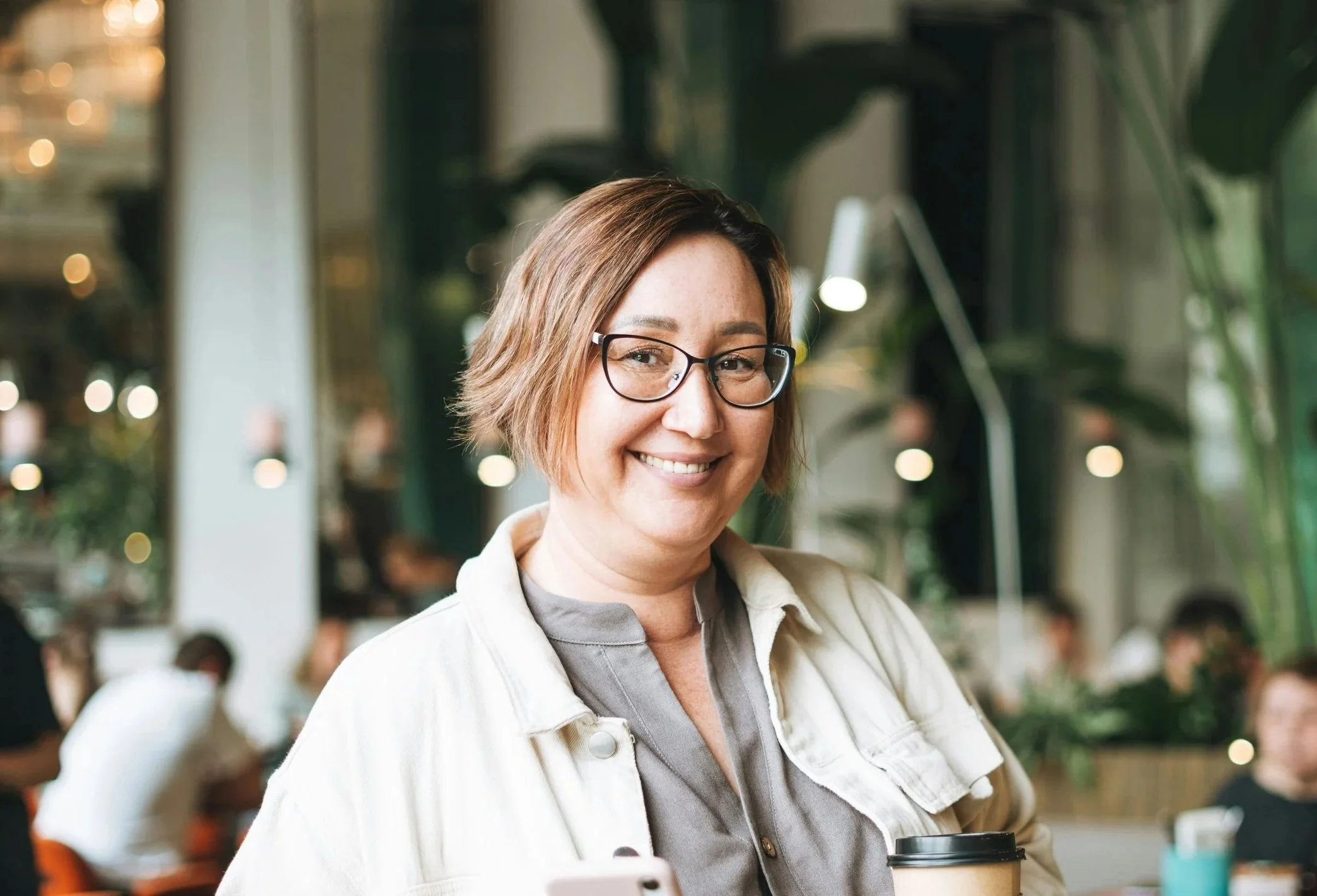 Smiling patient wearing glasses in a bright, modern setting