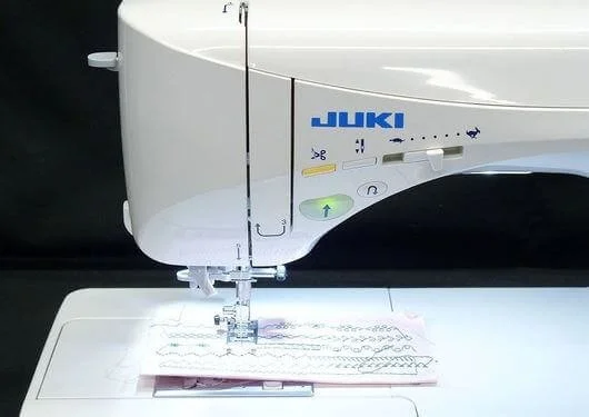 Close-up of a Juki sewing machine stitching fabric with multiple sewing lines.