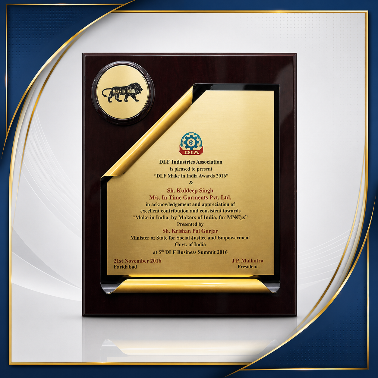 A framed award plaque with the logo of DLF Industries Association and a badge that says "Make in India." The plaque recognizes Sh. Kuldeep Singh from M/s. In Time Garments Pvt. Ltd. for contributions to 'Make in India' at the 5th DLF Business Summit 2016 in Faridabad on November 21, 2016, presented by Minister Sh. Krishan Pal Gurjar and President J.P. Malhotra.