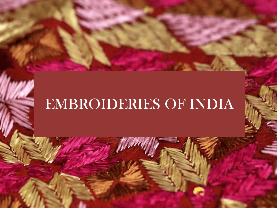 Close-up of colorful embroidered fabric with pink, gold, and beige thread, labeled 'Embroidery of India'.