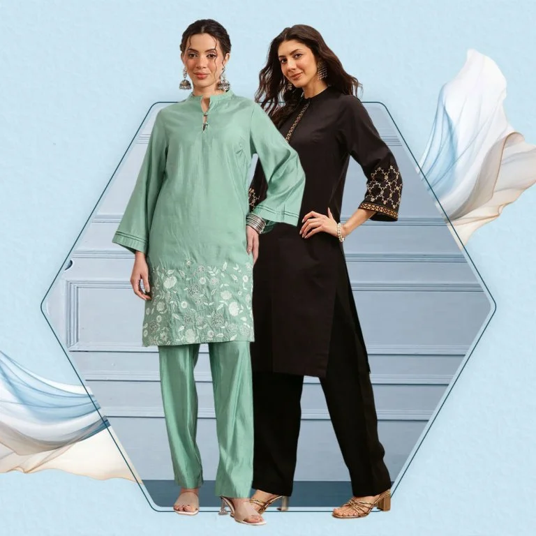 Two women standing in traditional South Asian attire on stairs with a light blue background.