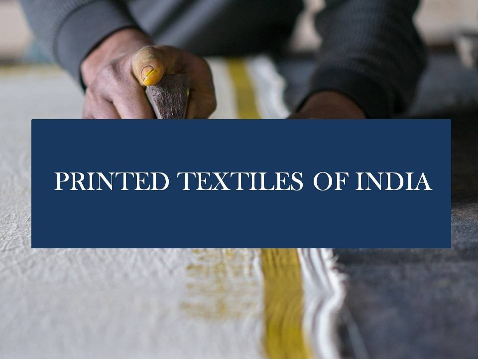 Close-up of a hand pressing a printing roller on fabric with the text 'Printed Textiles of India' overlayed.
