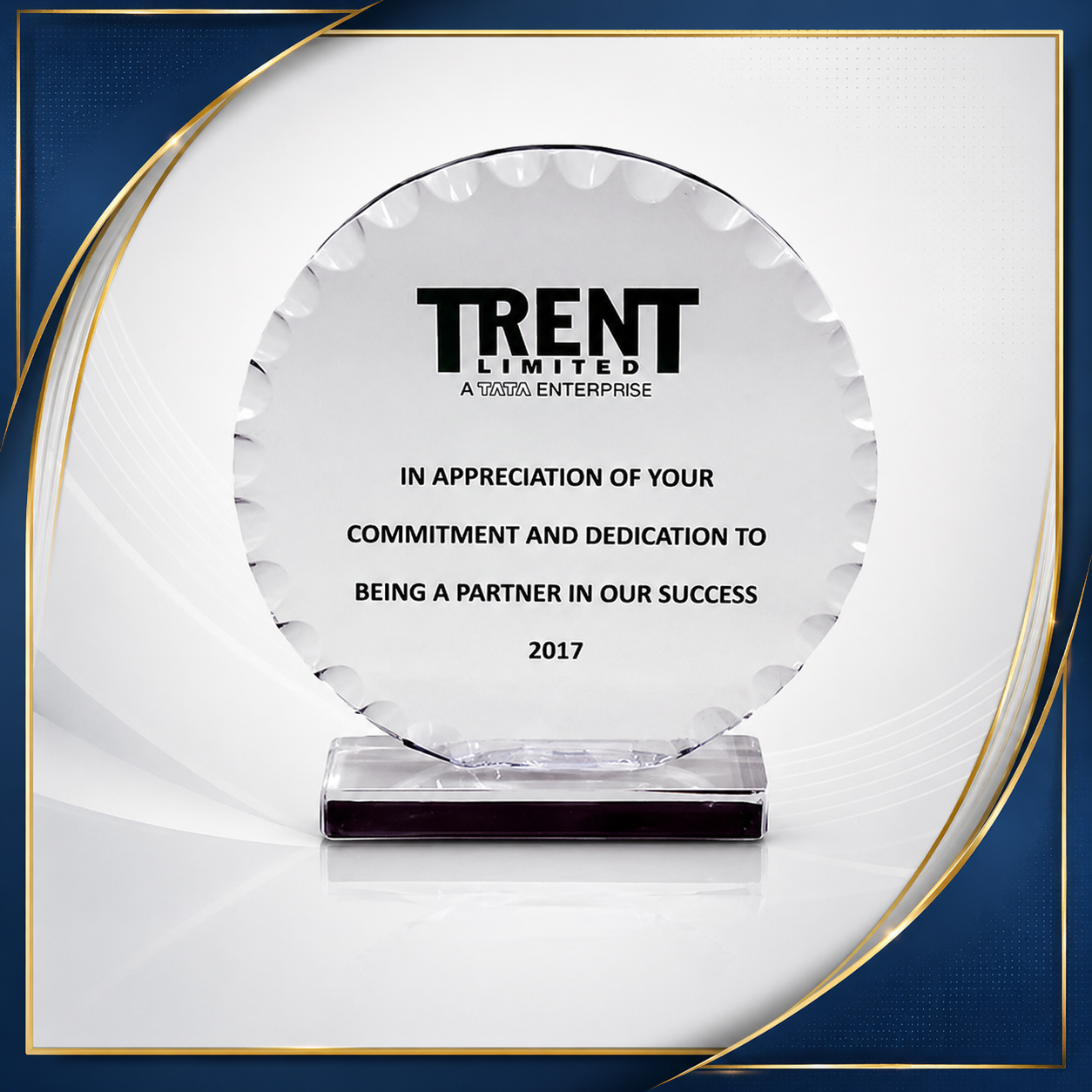 A glass award plaque with the logo and text from Trent Limited, Tata Enterprise, recognizing commitment and dedication in 2017.