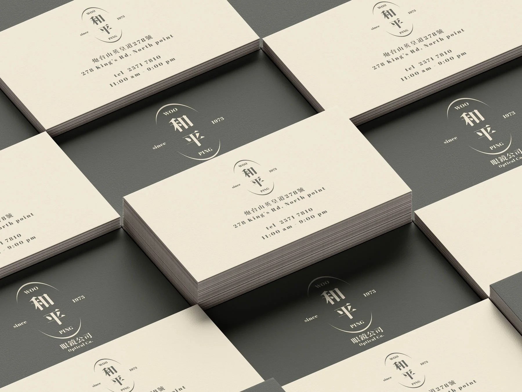 Multiple stacks of business cards with a design that includes Chinese characters, the word 'WOO,' 'since 1973,' 'PING,' the address '278 King's Rd, North Point,' a telephone number, and operating hours from 11:00 am to 9:00 pm.