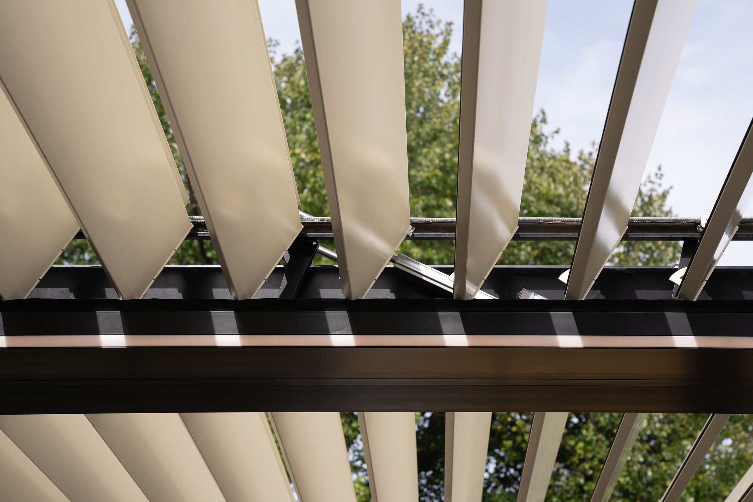 Moderne Lamellenpergola mit verstellbaren Aluminiumlamellen für optimalen Sonnen- und Wetterschutz auf Terrasse oder im Garten