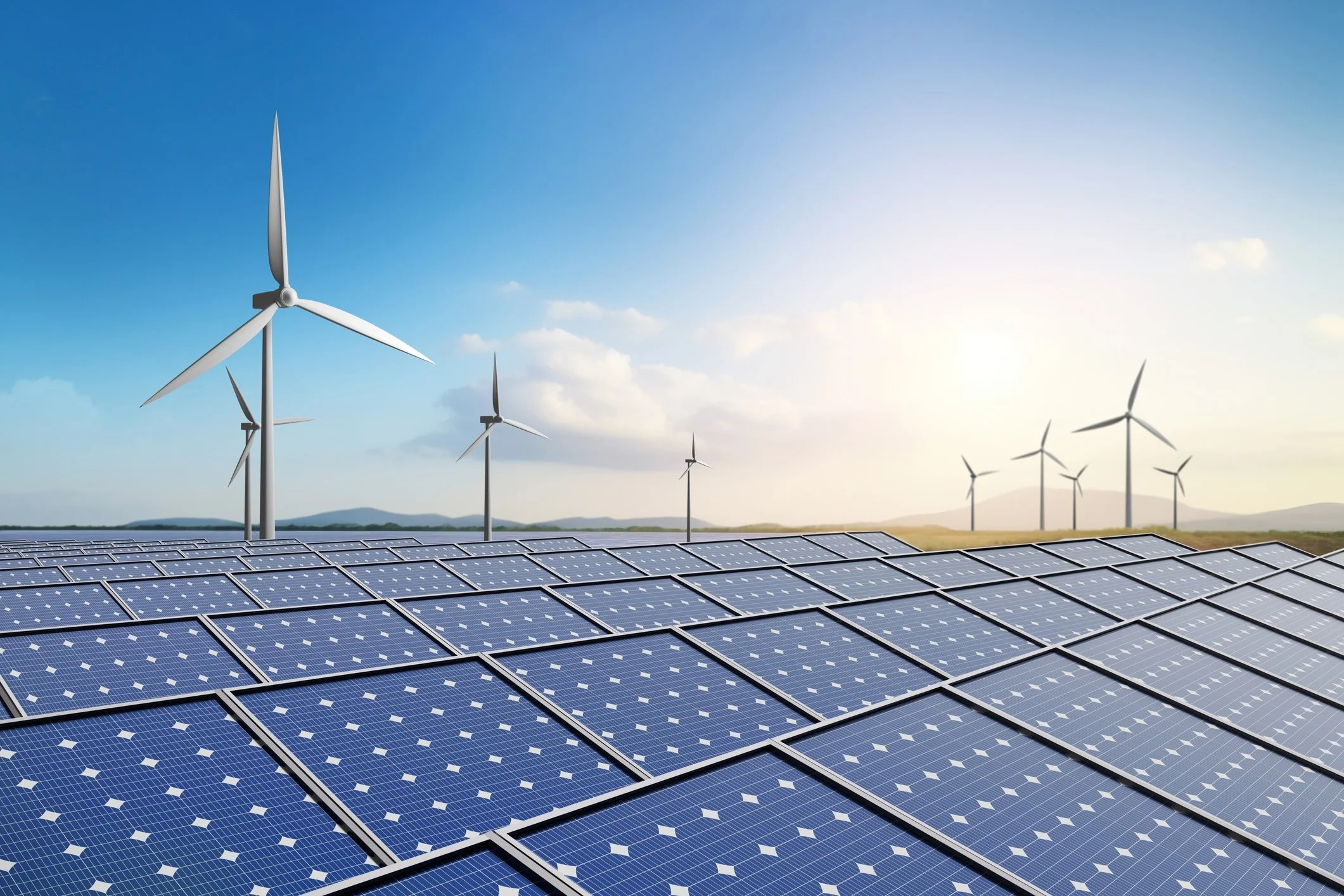 Solar panels and wind turbines under a bright sky, representing Poland's renewable energy investment.