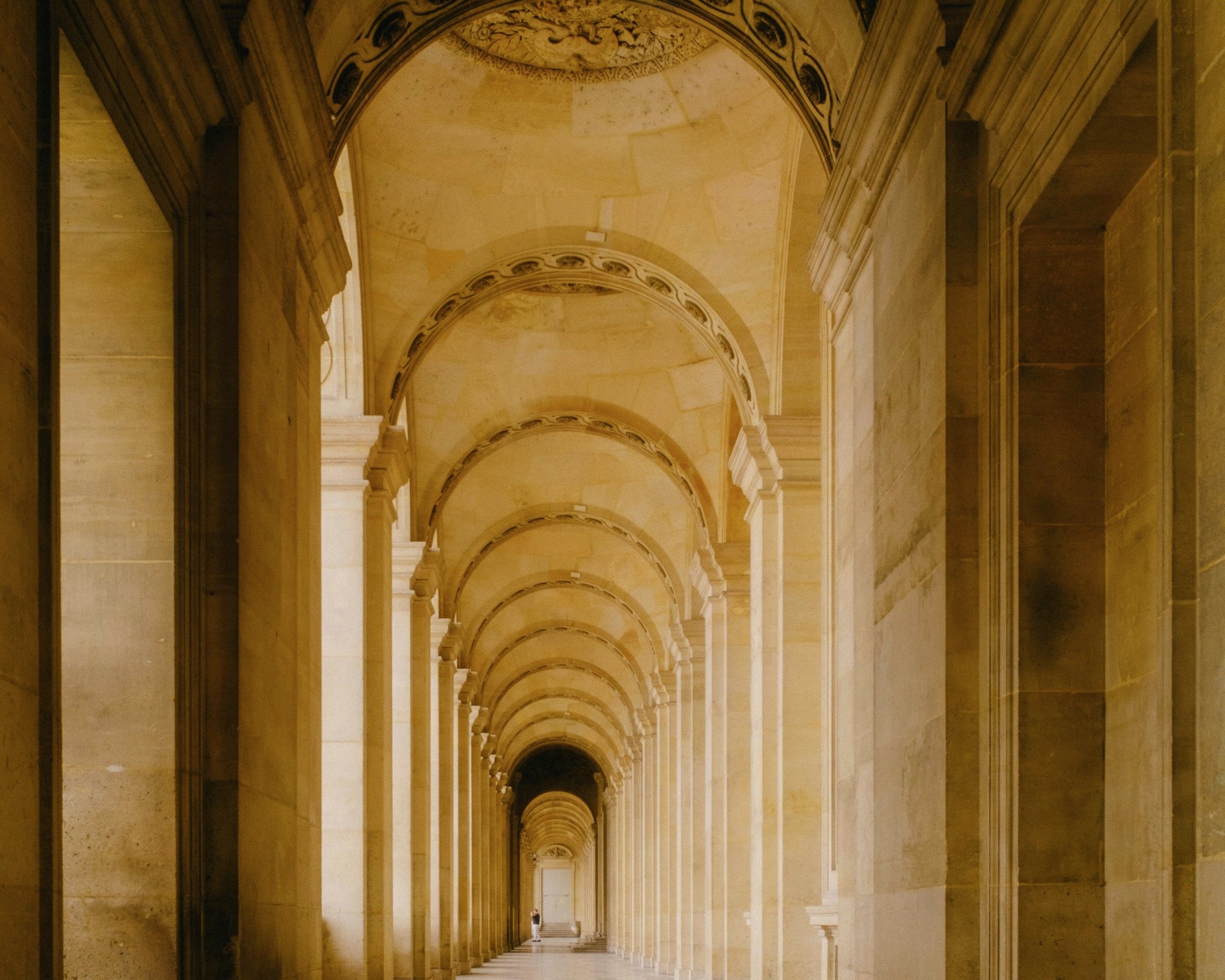 Stone colonnade with receding arches in warm light