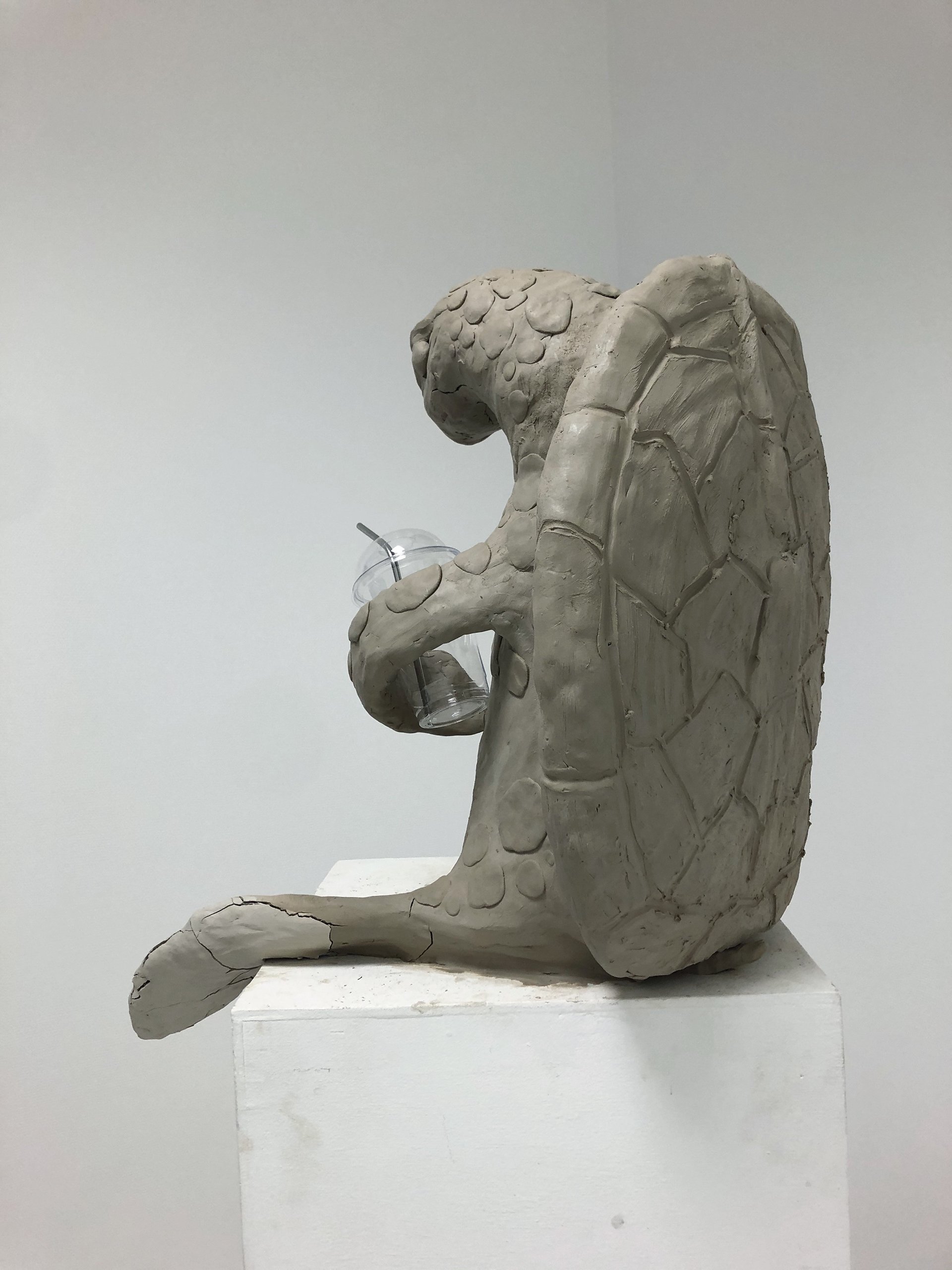 Skulptur av en Skilpadde skall, laget av hvit keramikk eller stein, viser krokodillens kropp og hode med fascinerende detaljer, plassert på en hylle.