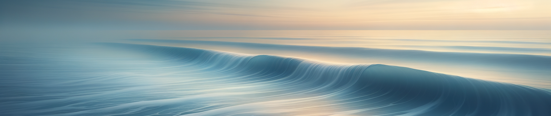Calm ocean waves with soft light reflecting on the water at sunset or sunrise.