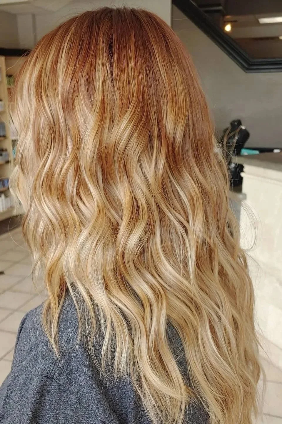 Wavy blonde hair with subtle highlights on a person sat indoors.
