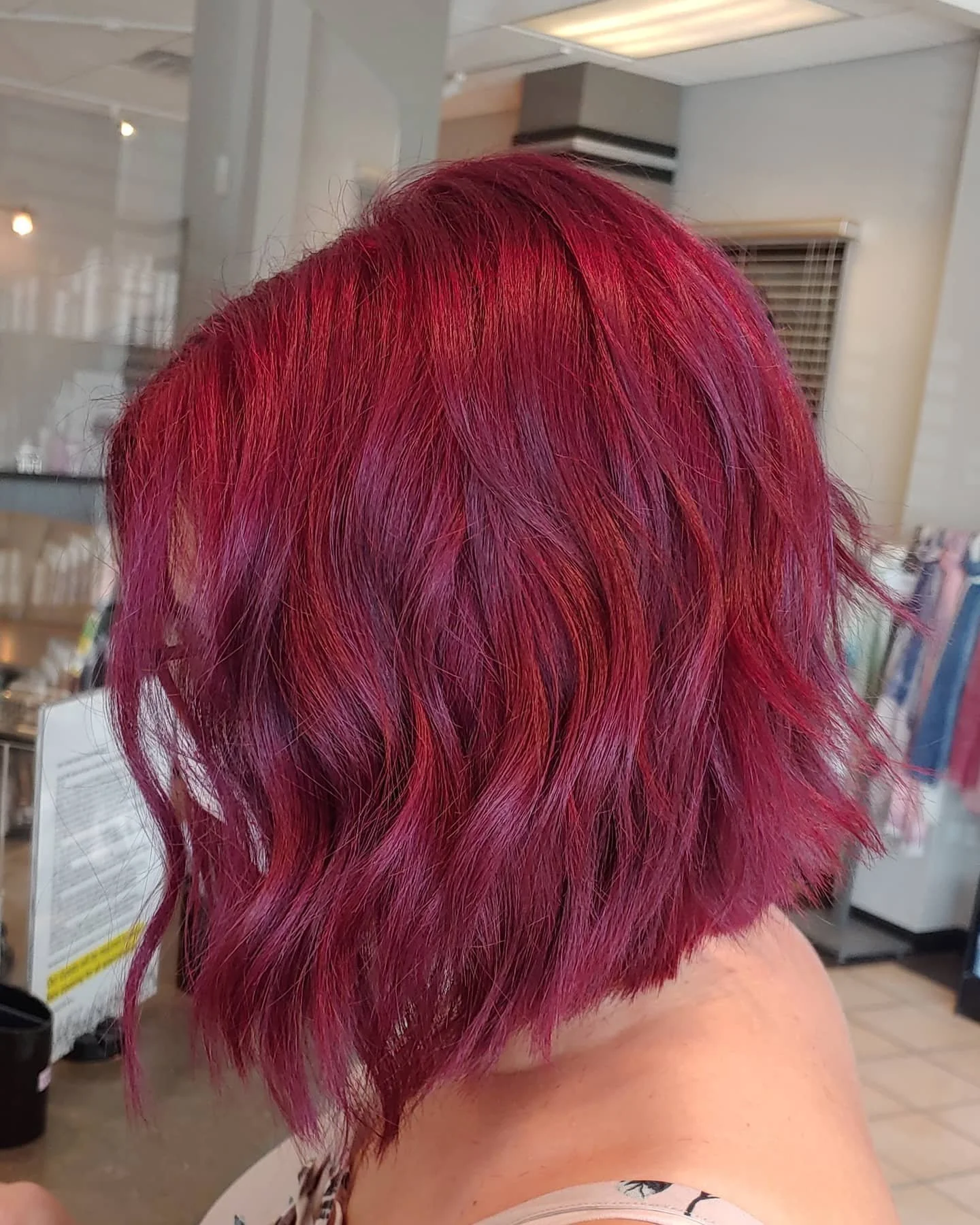 Close-up of a person's head with short, layered hair dyed in a vibrant red color.