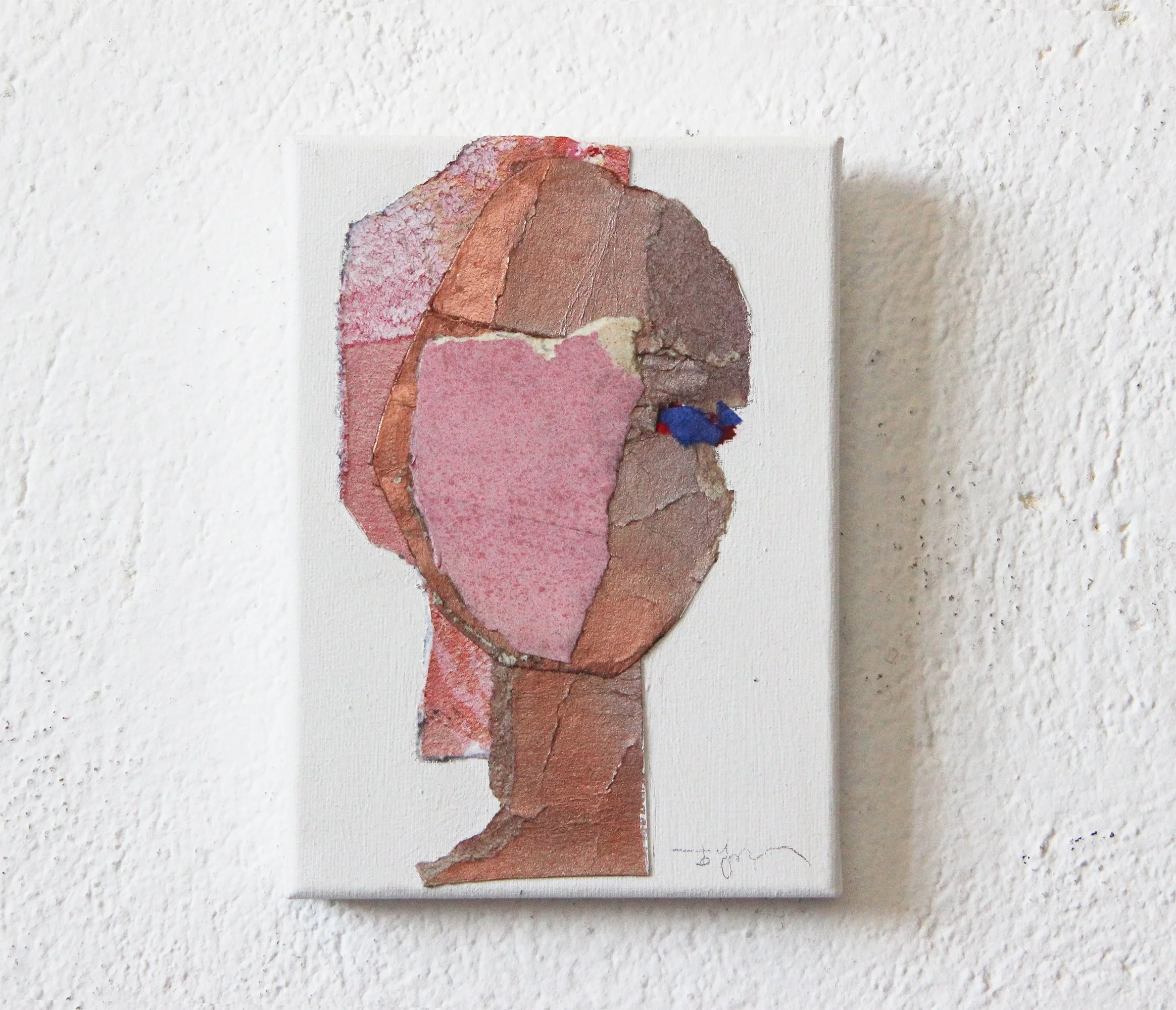 Mixed media portrait of a woman with a pink face, brown and beige hair, and only one eye visible, on a white canvas against a white textured wall.