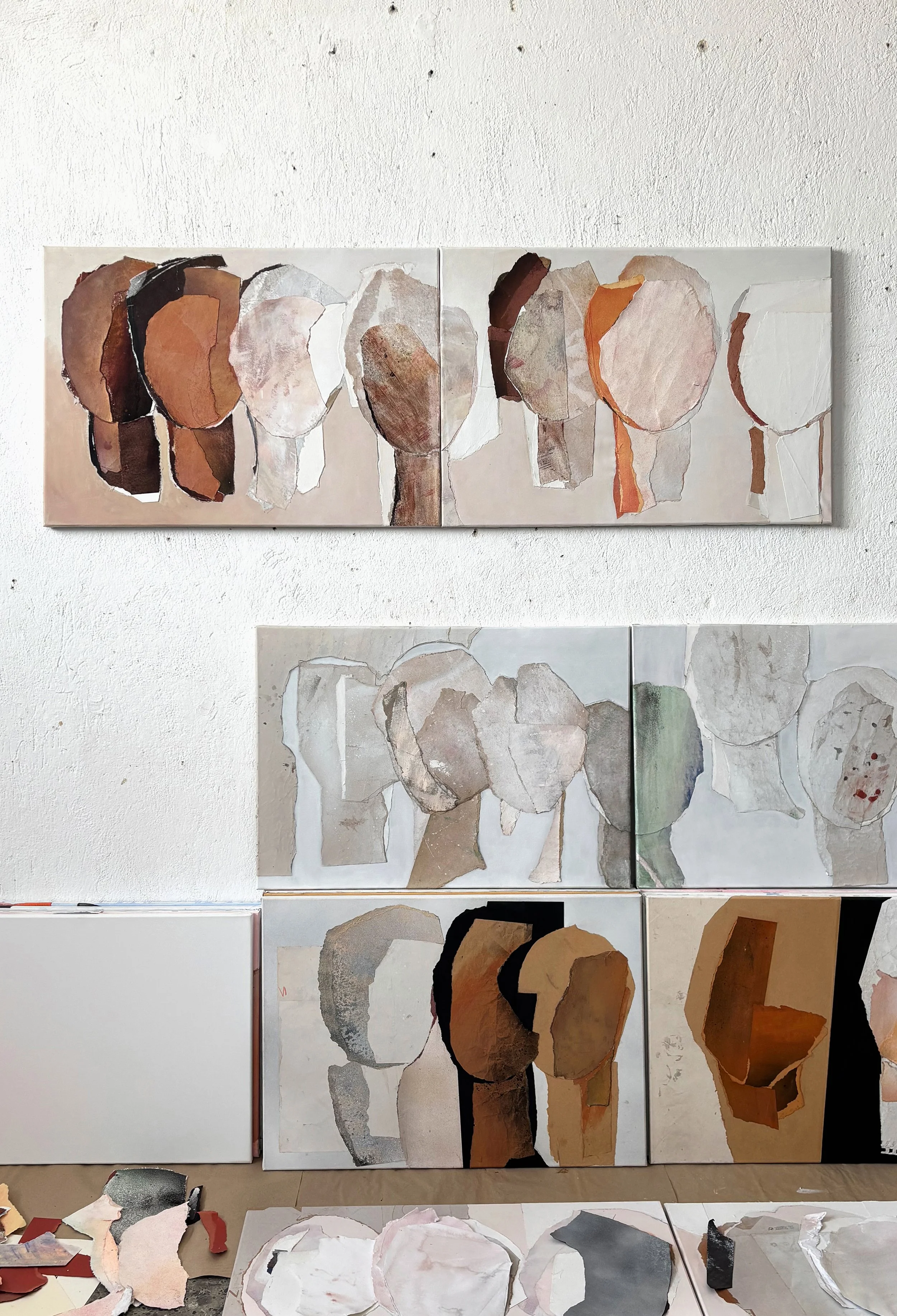 Collection of abstract art paintings depicting human heads and profiles using torn paper and mixed media on canvas, arranged on a gallery wall.
