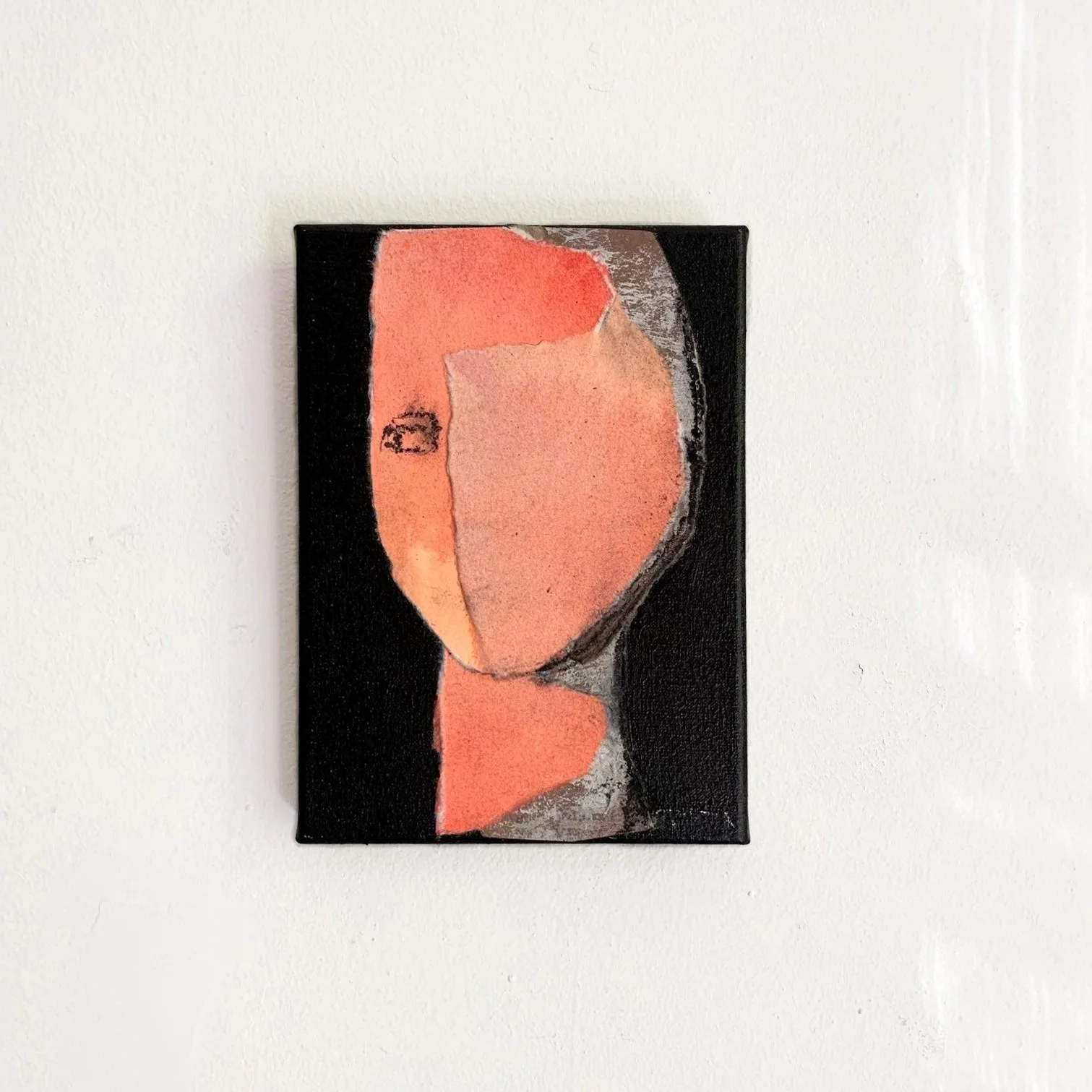 Abstract painting of a face with a black background and peach-colored features.