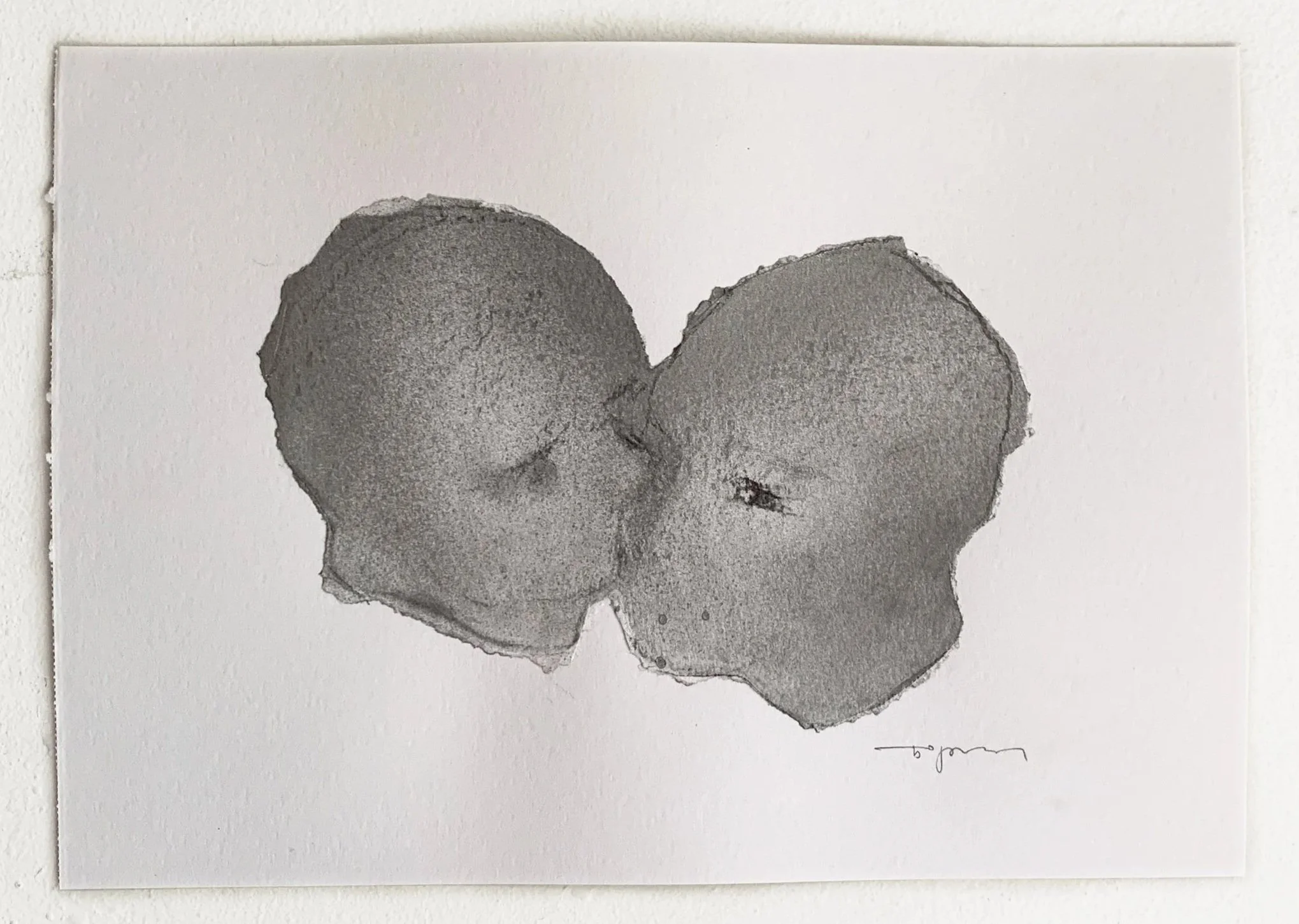 Black and white watercolor painting of two peach halves touching, mounted on a white wall.