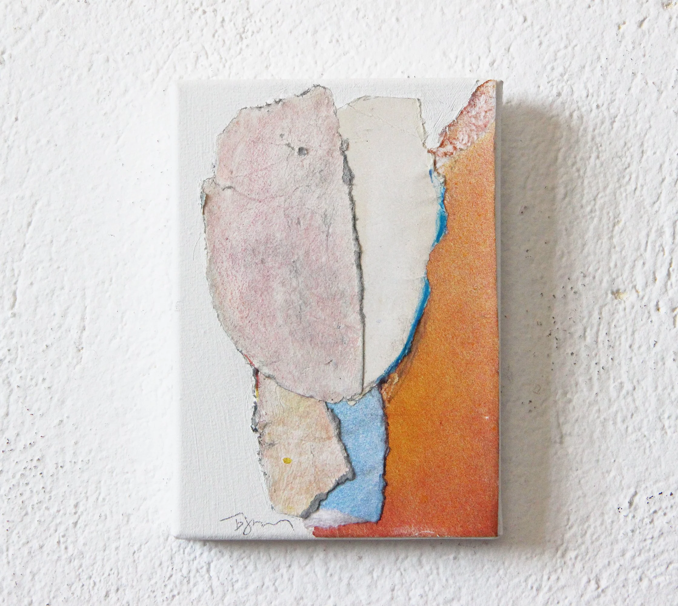 Abstract mixed media artwork on a white textured wall, featuring torn pieces of paper or canvas with pastel colors and rough edges.
